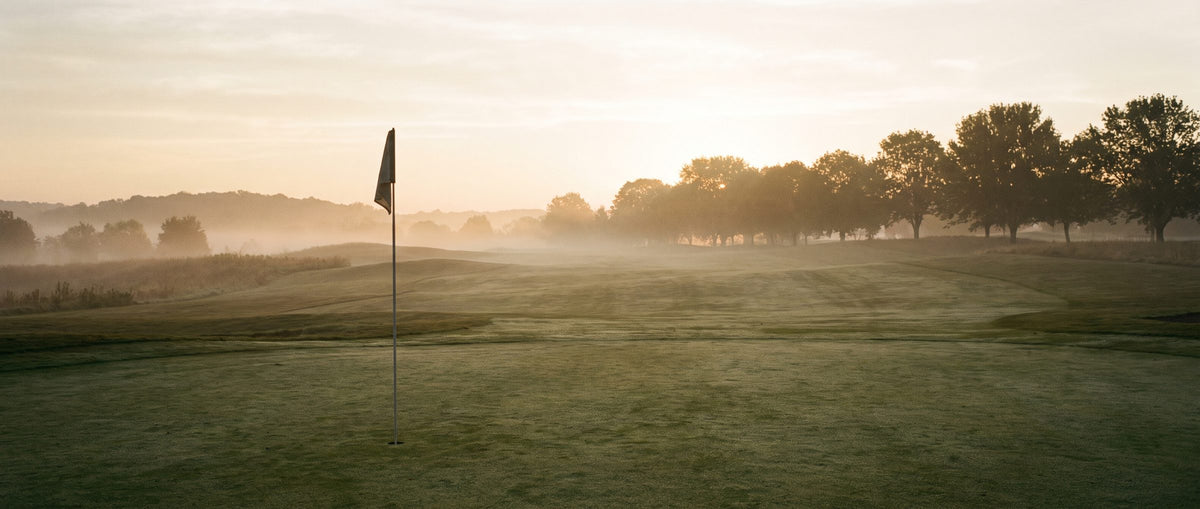Golfgrün mit Fahne im Morgennebel